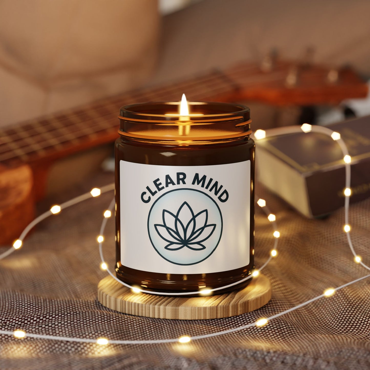 Candle labeled 'Clear Mind' with a guitar and string lights in the background